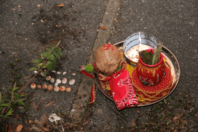 Seven betel-nuts, seven seashells and seven small stones placed on the ground